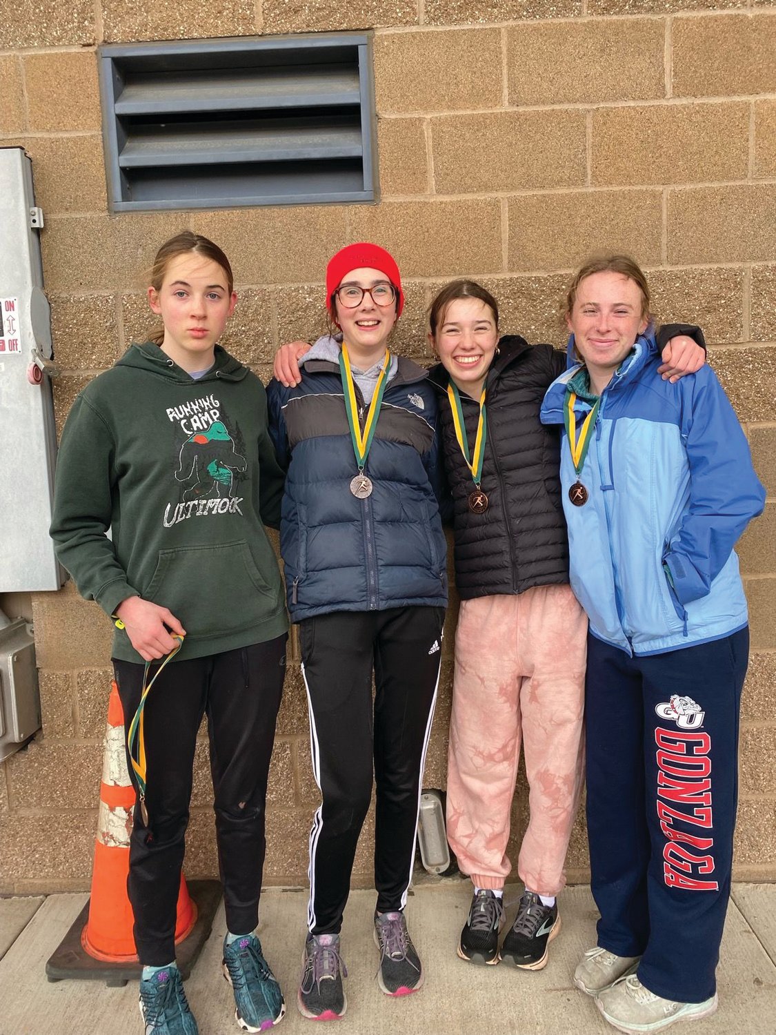 Rivals relay runners Fiona Fraser, Michael Gregg, Aliyah Yearian, and Camryn Hines pose together after earning bronze in the 4x800-meter relay in Bellingham.